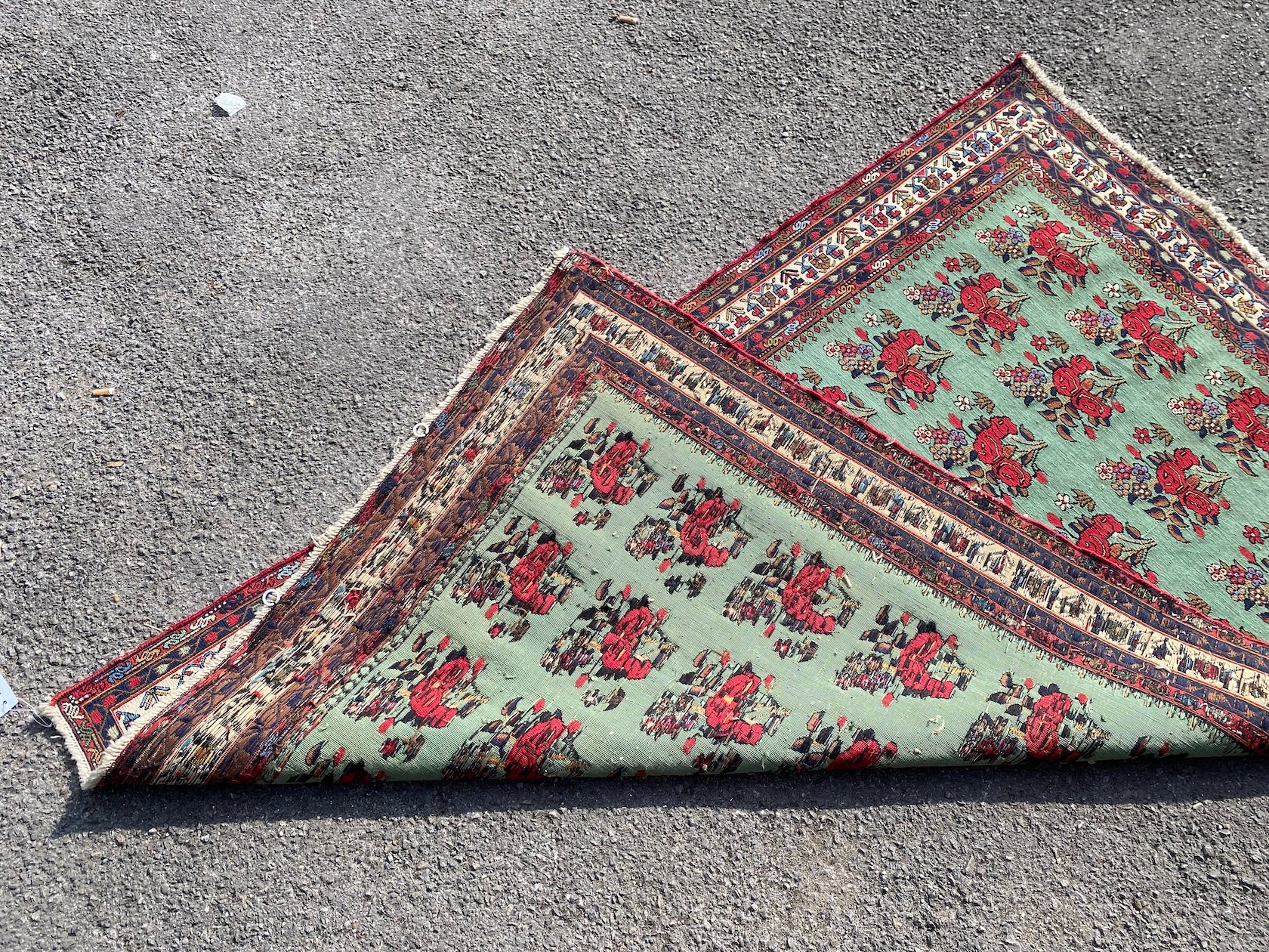 A Kirman Shah rug woven with floral bunches on a green ground within a conforming multi border 184cm X 120cm